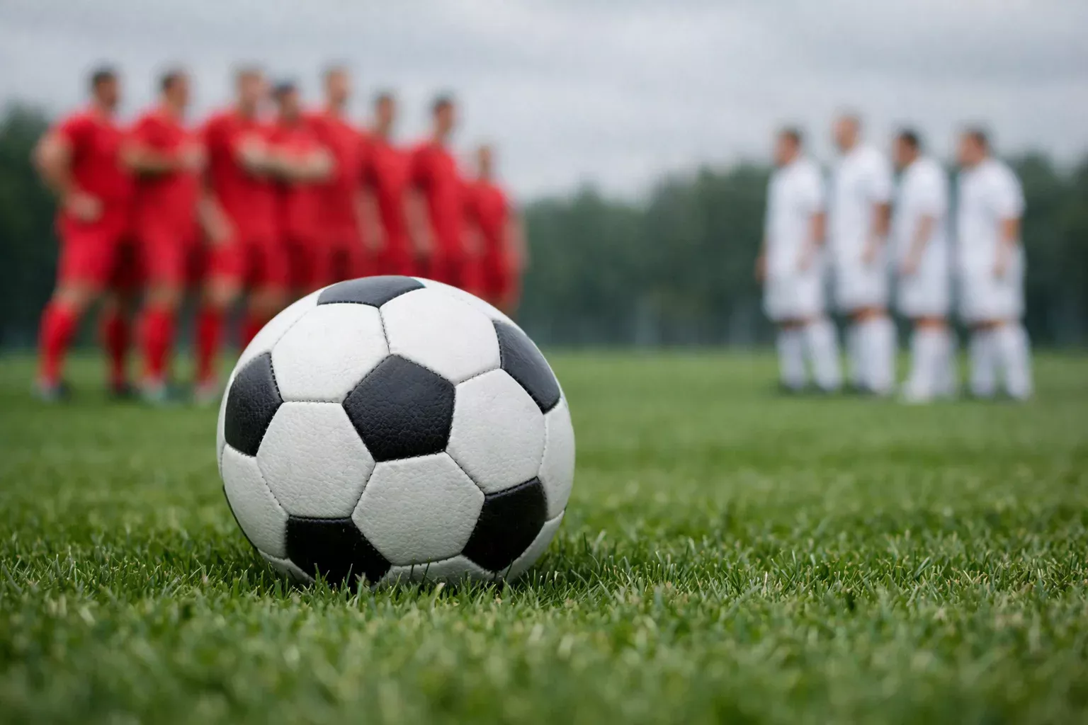 Nahaufnahme eines Fußballs auf dem Rasen mit Spielern im Hintergrund – symbolisch für Handicap-Wetten